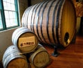 One huge wooden wine barrel with hoops and three medium barrels