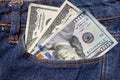 One hundred American dollars bills in a pocket of blue jeans Royalty Free Stock Photo