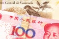 A bolivar note from Venezuela with a yuan note from the People`s Republic of China