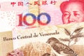 A bolivar note from Venezuela with a yuan note from the People`s Republic of China