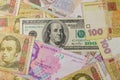 One hundred dollar bill on background of different ukrainian hryvnia banknotes
