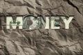 A one-hundred dollar bill is seen through the word money cut into wrinkled paper Royalty Free Stock Photo