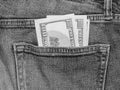 One hundred dollar bills in the back pocket of jeans, monochrome photo Royalty Free Stock Photo