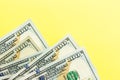 One hundred dollar bills cash lying on yellow background . Financial and business concept. Flat lay, mockup, overhead