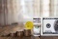 One hundred dollars banknotes of the stack of coins from quarters and one dollar. Royalty Free Stock Photo