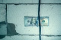 One hundred dollars is inserted between a thick black electrical wire and a wall of aerated concrete bricks.Bribery and corruption Royalty Free Stock Photo