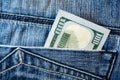 Pile of one hundred american dollar banknotes in the back jeans pocket. Close up one hundred US Dollar as symbol of poverty and Royalty Free Stock Photo