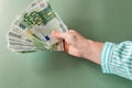 One hundred euro banknotes in female hands on a green background.salary of a woman in the Eurozone.