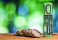 One hundred euro rolled bill banknote, with euro coins on green Royalty Free Stock Photo