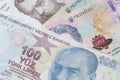 one hundred Tukish lira banknote lying on Ukrainian hrivnya banknotes