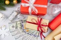 One hundred US dollar bills with gift boxes and Christmas decoration on light grey background. Concept of Christmas shopping Royalty Free Stock Photo