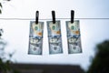 One hundred US dollar bills hanging pinned with clothespins close-up against a cloudy sky. Money laundering is illegal. Drying up Royalty Free Stock Photo