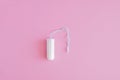 One hygienic tampon on a pink background.