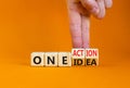 One idea and action symbol. Concept words One idea and One action on wooden cubes. Businessman hand. Beautiful orange table orange Royalty Free Stock Photo