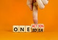 One idea and action symbol. Concept words One idea and One action on wooden cubes. Businessman hand. Beautiful orange table orange Royalty Free Stock Photo