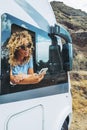 One independent woman using phone outside the window of her alternativ ehome camper van. People and travel destination with camper