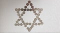 One israeli shekel metal coins arranged on white background in a shape of jewish six points star