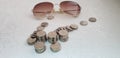 Israeli shekels spilled coins on white table with fashionable sunglasses