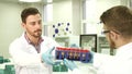 One lab technician hands over test tubes to his colleague for researches Royalty Free Stock Photo