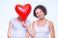 One lady hides her sisters face behind balloon