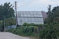 One large attic of a rural house under a gray slate roof behind a fence