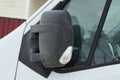 One large black closed plastic car mirror next to the gray glass