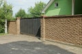 One large black metal gate and part of a brown wall
