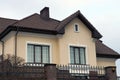 One large brown private house with windows under a tiled roof against a gray sky Royalty Free Stock Photo