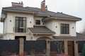 One large brown private house with windows under a tiled roof against a gray sky Royalty Free Stock Photo