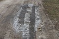 One large frozen puddle with dirty white gray ice on the road