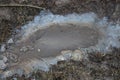 One large frozen puddle with dirty white gray ice on the road