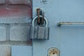 One large gray padlock on an iron gate