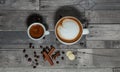 One large and one small cup of cappuccino coffee and latte on a coarse wooden gray background, decorated with small sweets, black Royalty Free Stock Photo