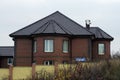 One large private brown brick house with windows under a tiled roof