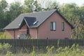 One large private brown house with windows under a gray tiled roof Royalty Free Stock Photo