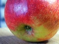 One large red apple on a wooden surface, a macro  shot Royalty Free Stock Photo