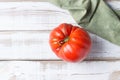One large red tomato on a light wooden background. Ugly food Royalty Free Stock Photo