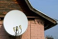 large white satellite dish on a brown brick wall Royalty Free Stock Photo