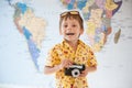 One little adorable caucasian kid with vintage camera laughing happy on world map wall background Royalty Free Stock Photo