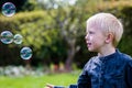 One Little boy blows soap bubbles in the garden on a summer day Royalty Free Stock Photo