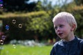 One Little boy blows soap bubbles in the garden on a summer day Royalty Free Stock Photo