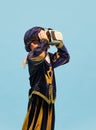 One little boy in costume of medieval pageboy, little prince wearing VR headset standing over blue background. Emotions