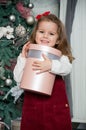 One little Caucasian cute girl smiling with present box in his hand in the festive New year studio room Royalty Free Stock Photo