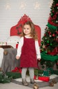 One little Caucasian cute girl smiling with present boxes in the festive New year studio room Royalty Free Stock Photo