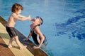 One little girl and little boy playing in the pool Royalty Free Stock Photo