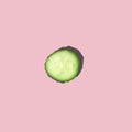 One lobule close-up of fresh cut cucumber with hard light on a pink background.