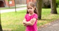 One lone offended child, sad anxious angry lone little girl standing slightly upset, kid with arms crossed, closeup, portrait Royalty Free Stock Photo