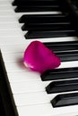 One lone rose petal of pink scarlet lies on black and white piano keys. romantic music, lightness and romance of relaxation and Royalty Free Stock Photo