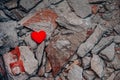One lonely heart against background of broken concrete fragments. Unhappy love relationships. Infidelity and betrayal