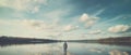 One lonely man standing on the shallow edge of a vast lake, gazing into the horizon, looking at the calm lake Royalty Free Stock Photo